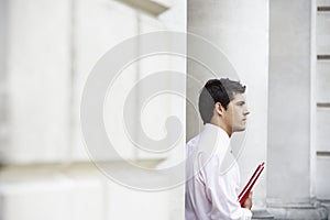 Thoughtful Young Businessman Holding File