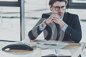 thoughtful young businessman sitting at workplace