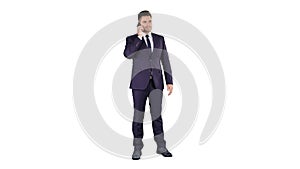 Thoughtful young businessman in suit and tie making several calls quickly on white background.