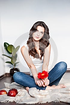 Thoughtful young casual female with red flower