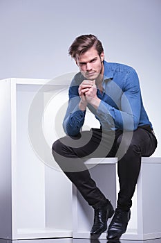 Thoughtful young casual man is sitting