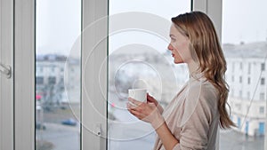 Thoughtful young girl contemplating European city street holding cup. 4k Dragon RED camera