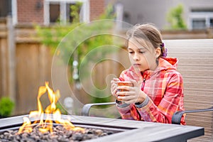 Thoughtful young girl sitting by the Fire