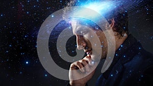 Thoughtful young man, creative mind concept. A man with a galaxy in his head,