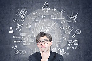 Thoughtful young man in glasses, business strategy