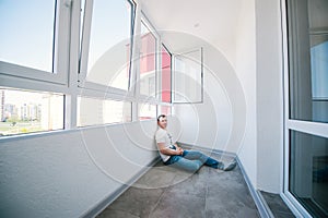 Thoughtful young man sitting in a empty balcony