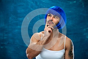 Travesti person posing on blue backdrop photo