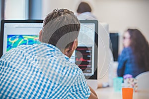 Thoughtful young programmer coding on computer