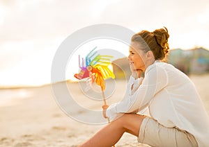 Thoughtful young woman with colorful windmill toy