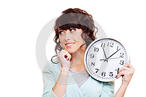 Thoughtful young woman holding clock