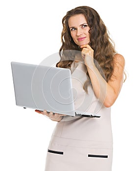 Thoughtful young woman with laptop