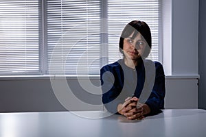 Thoughtful Young Woman Sitting Alone At Desk