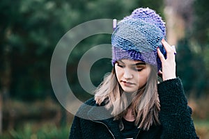 Thoughtful young woman in woolen violet blue cap