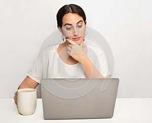 Thoughtful young woman working on a laptop
