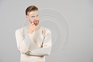 Thoughts and doubts concept. Man bearded thoughtful face, grey background. Man with beard unshaven guy looks handsome