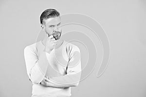 Thoughts and doubts concept. Man bearded thoughtful face, grey background. Man with beard unshaven guy looks handsome