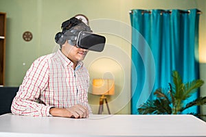 thougtful Young man with virtual reality headset looking empty table at home - concept of modern technology, cyberspace