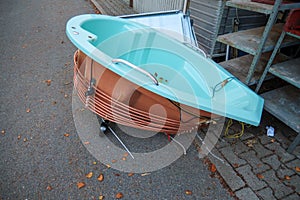 on thr garbage lies a discarded bathtub surrounded with copper pipes