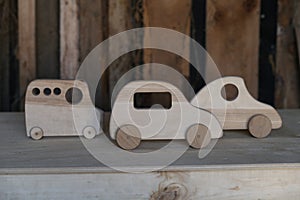 thre toy car made of hand-made wood and located on a plywood table, a fuzzy background of untreated, unplaned boards.Deforestation