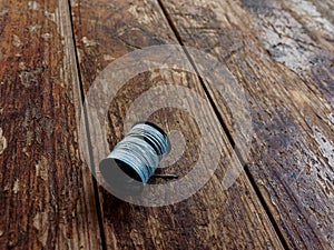 Thread and needle on a wooden old background