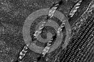 Thread seam on black leather material as background