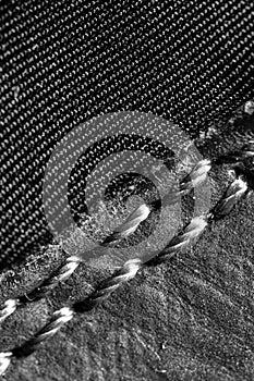 Thread seam on black leather material as background