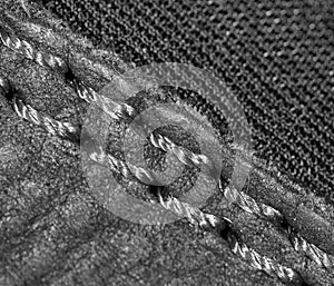 Thread seam on black leather material as background