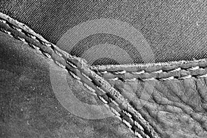 Thread seam on black leather material as background