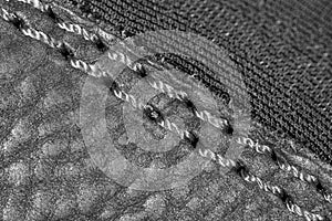Thread seam on black leather material as background