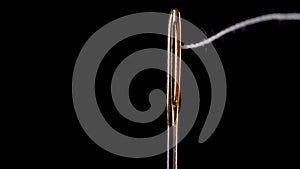 Thread for sewing is threaded into the eye of a needle. Sewing needle.