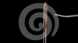 Thread for sewing is threaded into the eye of a needle. Sewing needle.