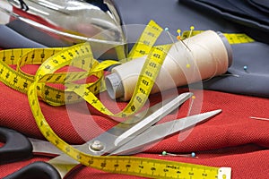 Thread Spools, Pin and Yellow Measuring Tape and Large Dressmaking Scissors.