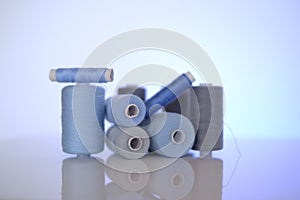 thread spools. Sewing threads set.Blue and gray thread spools on a blue background.Needlework and sewing