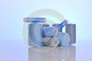 thread spools. Sewing threads set.Blue and gray thread spools on a blue background.Needlework and sewing concept.