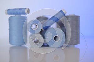 thread spools. Sewing threads set.Blue and gray thread spools on a blue background.Needlework and sewing concept.Hobby