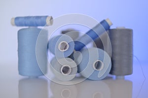 thread spools. Sewing threads set.Blue and gray thread spools on a blue background.Needlework and sewing .Hobby and