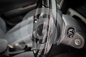 Threadbare automotive black leather steering wheel of old auto