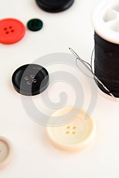 Threaded needle, black thread spool and buttons