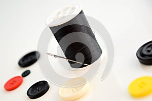 Threaded needle, black thread spool and buttons
