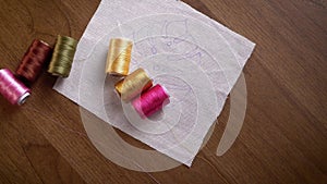 Threaded Symphony: Rolling Colorful Spools Onto Embroidery Pattern