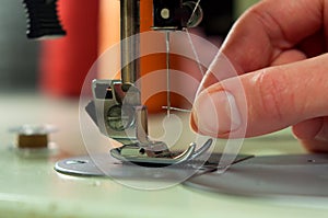 Threading the needle in a sewing machine.