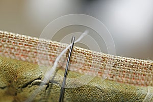 Threading a needle thread.