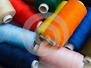 Threads of different colors on spools, irregularly scattered
