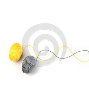 Threads for knitting fashionable sweaters. Yellow and gray ball of woolen thread on a white background. Illuminating and
