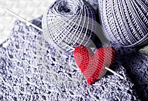 Threads with red handmade knitted heart