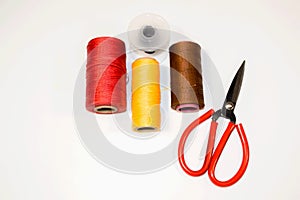 Threads and scissors top view on a white background