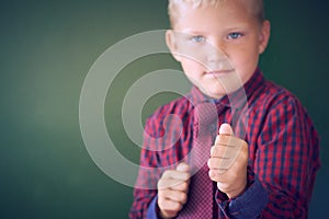 Threatening 5-year old boy looking violent with fists in the forefront, acting like a little bully at school, contrast