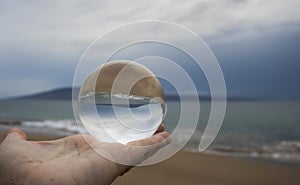 Threatening Clouds over Ocean Island and Sand Captured in Glass