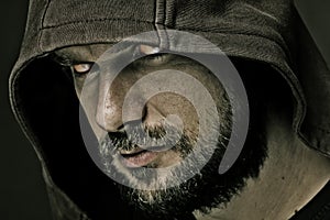 Threatening man with beard wearing a hood photo