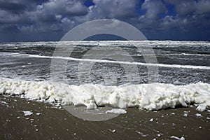 Threatening skies above heady surf with foam cups